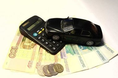 Économiser sur son budget voiture. Une calculette, une mini voiture et des billets de banque.