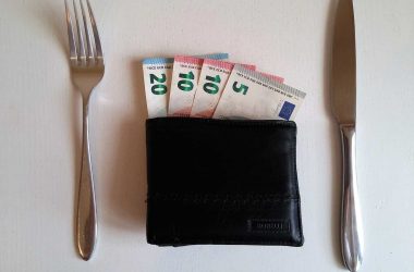 Comment être riche. Portefeuille avec des billets de banque entourè d'un couteau et d'une fourchette.