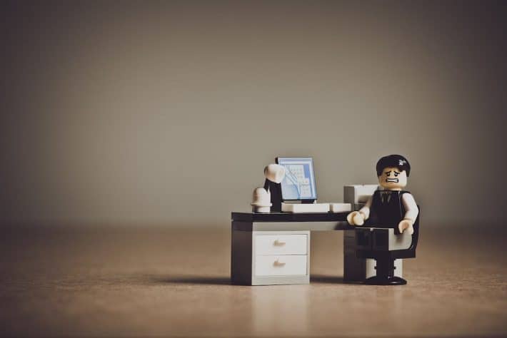 L'importance du travail. Quel travail faire ? Un personnage lego anxieux devant un bureau.