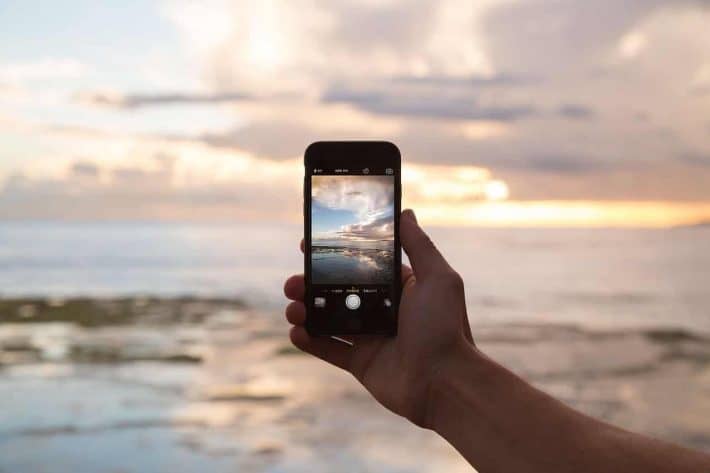 Gagner du temps et de l’argent. Un smartphone et un soleil couchant.